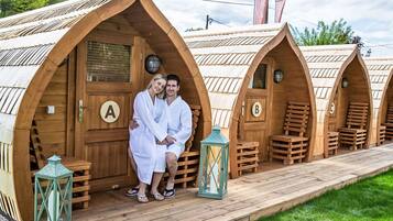 Eine Reihe von schlafcontainerartigen Unterkünften aus Holz, jeweils mit individuell gekennzeichneten Türen.