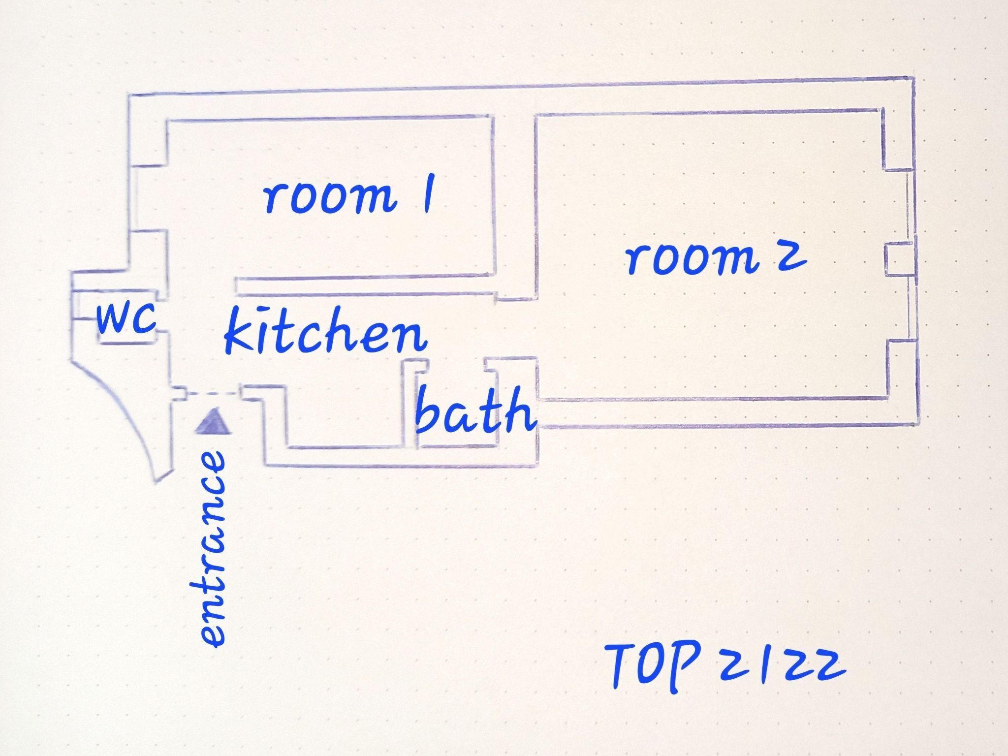 Ein Grundriss mit zwei Zimmern, einer Küche, einem Badezimmer und einem Eingangsbereich.