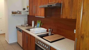 Una cocina moderna con armarios de madera, estufa de acero inoxidable y cafetera.