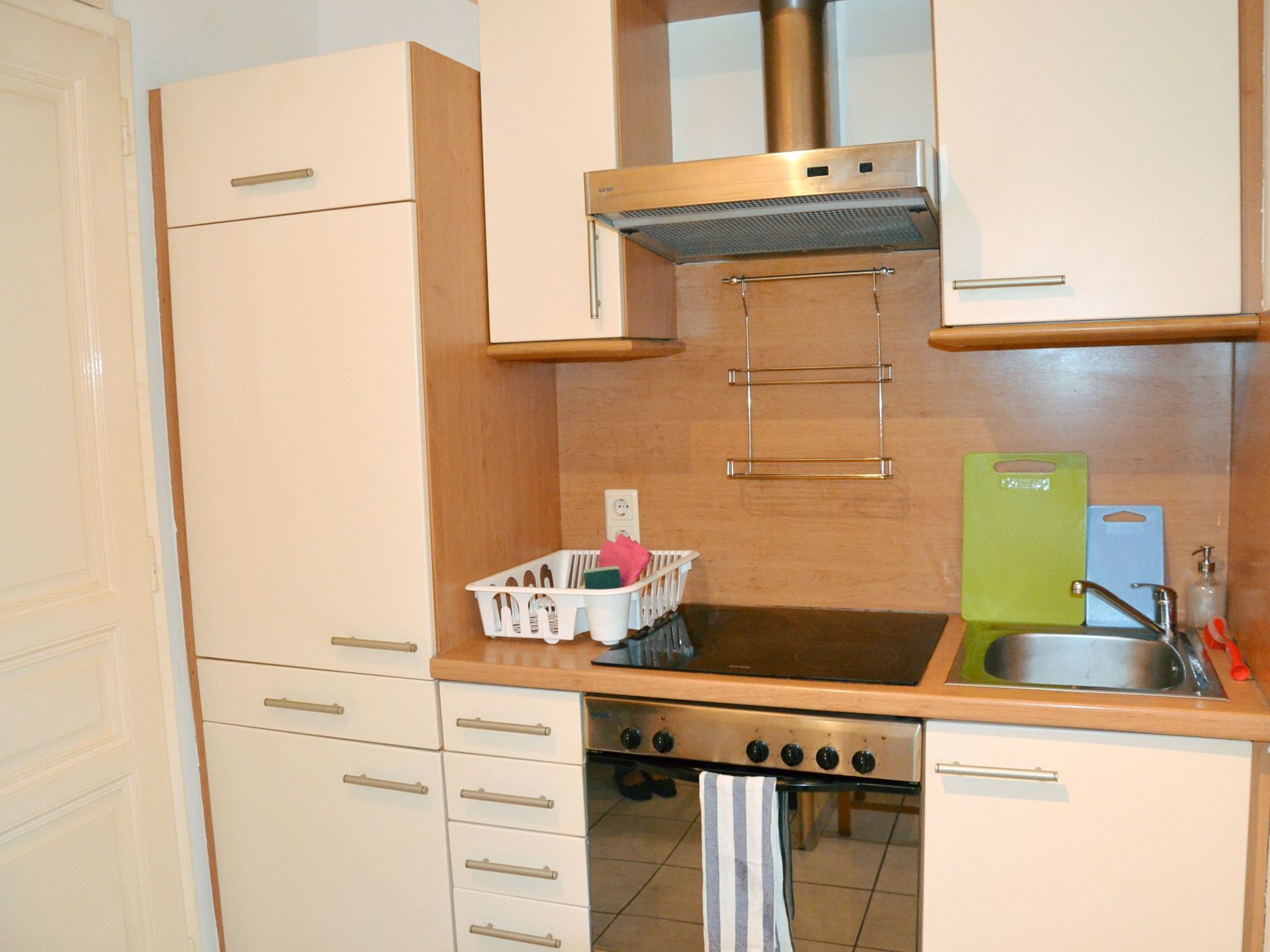 A compact kitchen with a stove, sink, and cabinets.