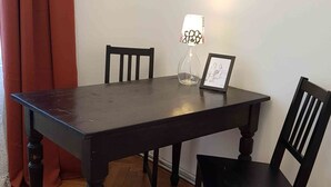 Spisebord med fire stole, en lampe og et indrammet billede på bordet.