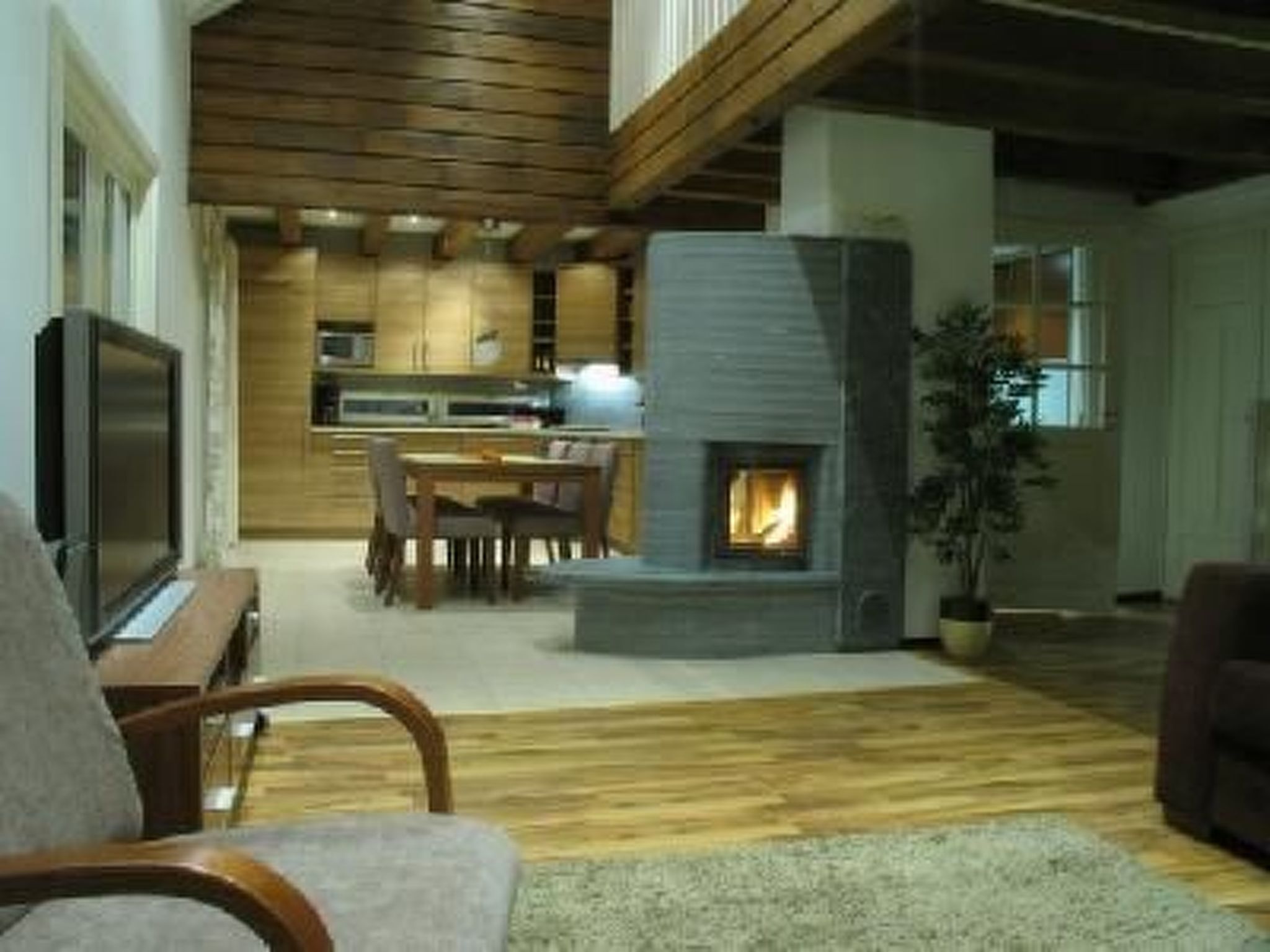 Un salon moderne avec une cheminée, un plancher en bois et un téléviseur.