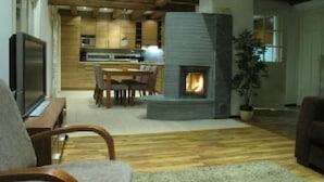 A modern living room with a fireplace, wooden flooring, and a television.