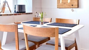 A dining area with a wooden table, chairs, and a pendant light.