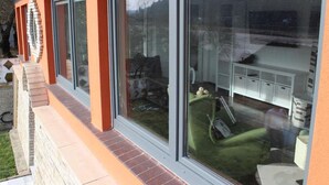 A modern building with large sliding glass doors, a brick base, and a white upper section. - Bungalow "Schönblick" am Elberadweg in Pirna by Interhome (Pirna)