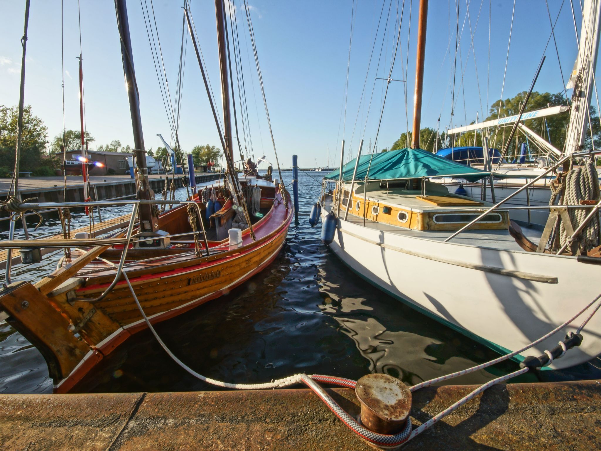 Un bateau en bois était amarré dans une marina, et un autre bateau se trouvait à proximité.