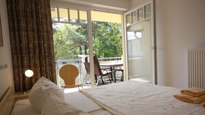 A hotel room with a bed, a chair, a table, and a view of the outdoors. - Appartement in Koserow mit Grill und Garten by Interhome (Koserow)