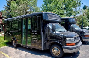 Um ônibus preto com a inscrição "Beaver Creek West" na lateral, indicando que é um ônibus de turismo.