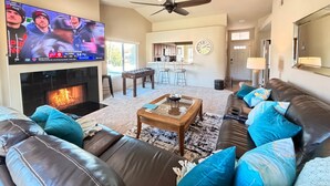 Ein Wohnzimmer mit Kamin, Fernseher, Sofa und Couchtisch.