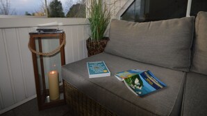 Zona d'seure a l'exterior acollidora amb una banca amb coixins, una espelma i un llibre anomenat "Rügen".