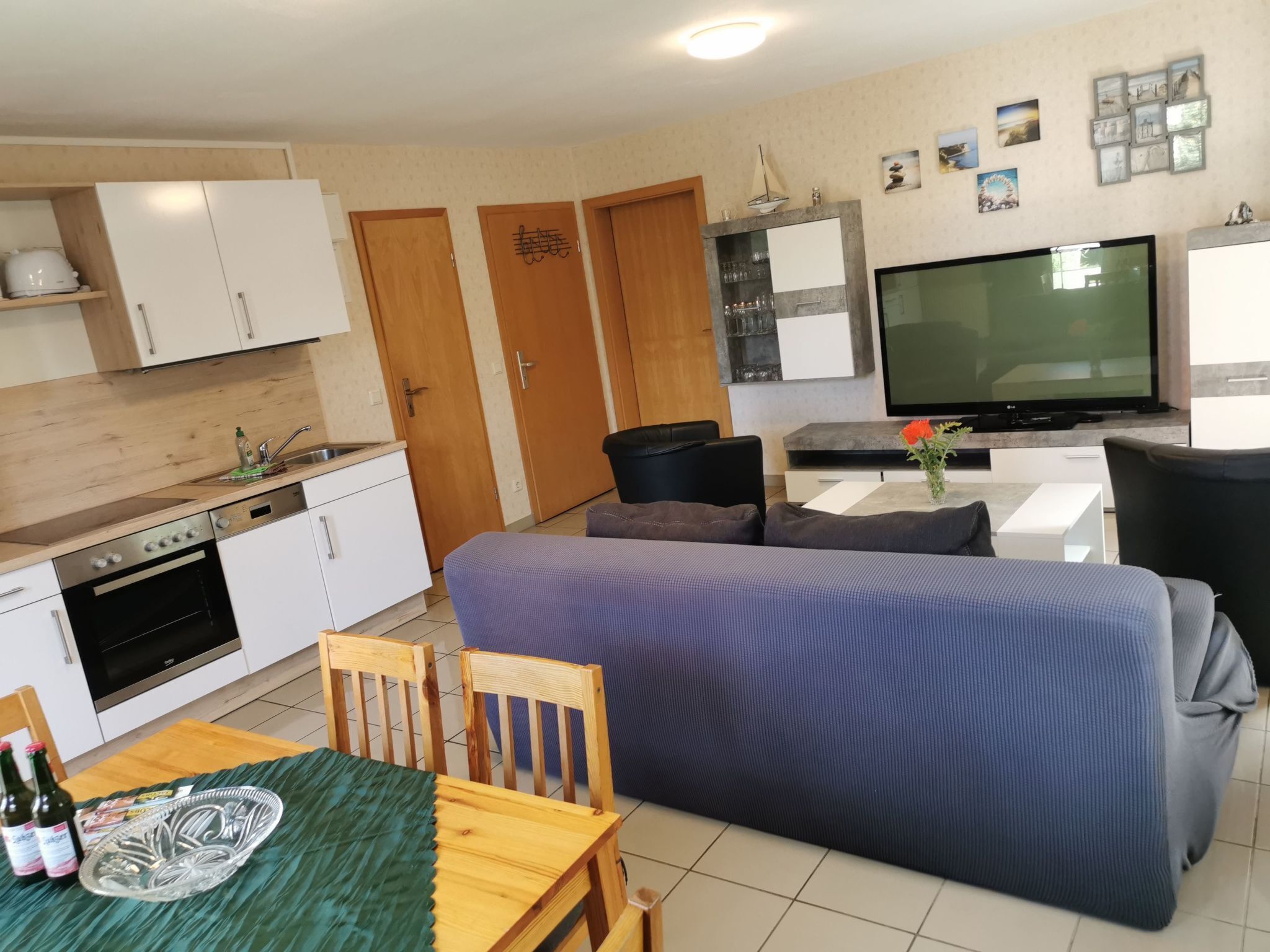 A compact living space with a kitchenette, a dining area, and a seating area with a TV.