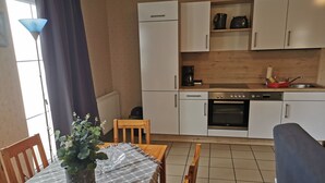 A compact kitchen with white cabinets, a built-in oven, and a coffee maker. - Apartment Breege by Interhome (Breege)