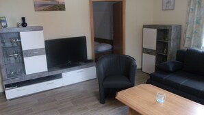 A modern living room with a TV, sofa, and coffee table. - Juliusruh by Interhome (Breege)