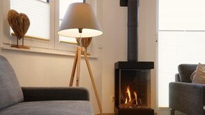 Una sala moderna con un sofá, una lámpara de pie y una estufa de leña.