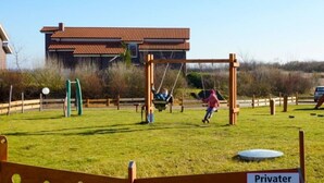 Ein Spielplatz mit Schaukeln und einem Schild, das ihn als privaten Spielbereich kennzeichnet.