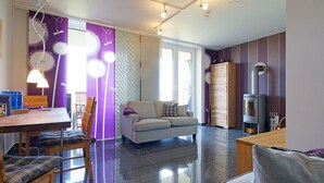 Un salon moderne comprenant un canapé, une table à manger et un coin cuisine avec une cuisinière.