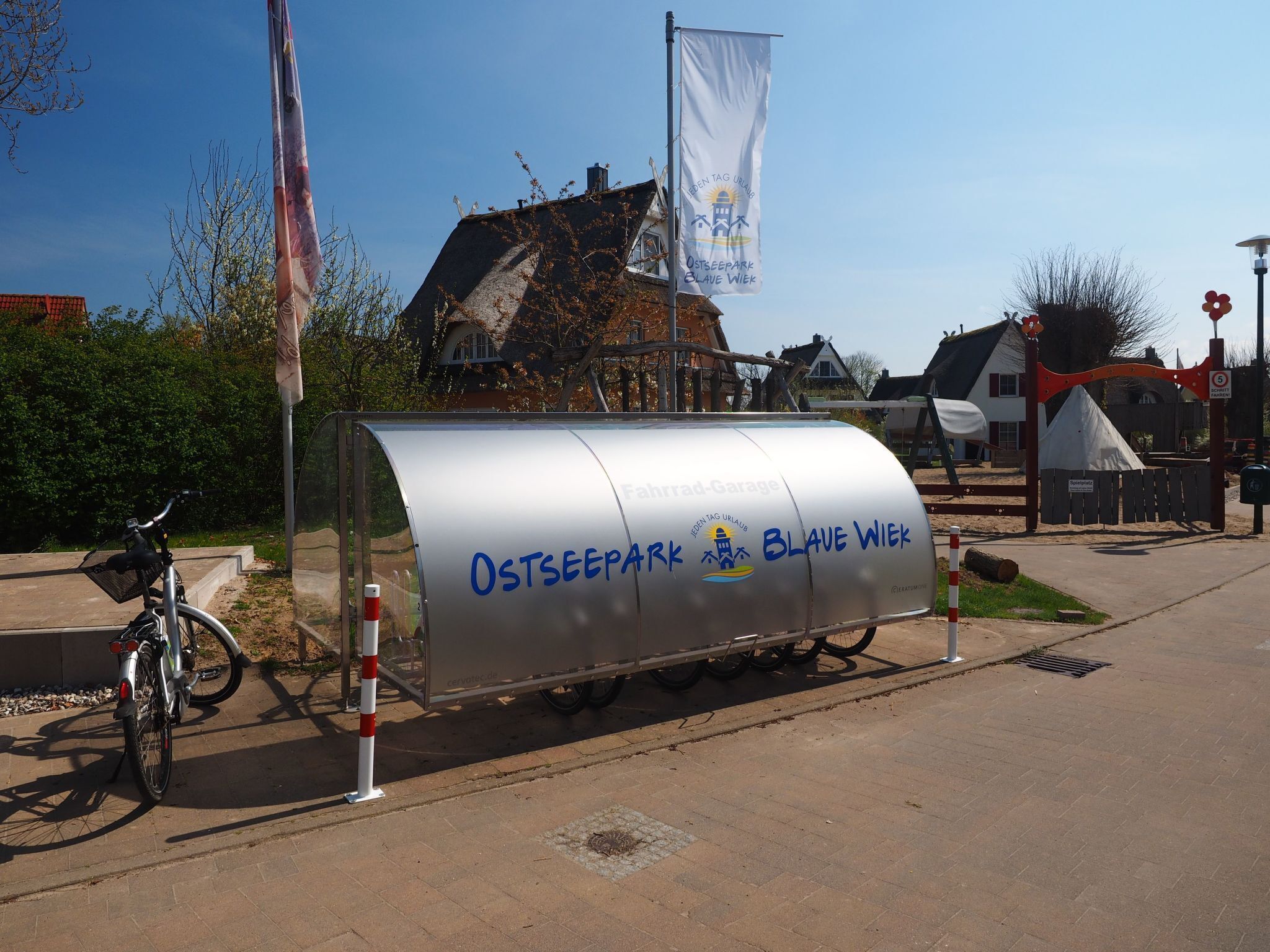 A covered bicycle parking area with a sign reading "Ostseepark Blave Wiek".