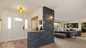 A living room with a stone fireplace, a sofa, and a coffee table.