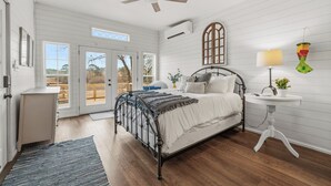 A bedroom with a bed, a bedside table, a lamp, and a window. - Lake Hamilton Retreat, Main House, Guest House, Sleeps Up to 14, Private Dock (Hot Springs)