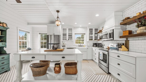 A kitchen with white cabinetry, a central island, and a patterned floor. - Lake Hamilton Retreat, Main House, Guest House, Sleeps Up to 14, Private Dock (Hot Springs)
