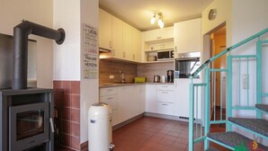 A modern kitchen with white cabinets, a built-in oven, a stove, and a trash can. - Haus Arberblick by Interhome (Zandt)