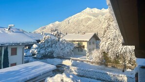 A residential area with houses covered in snow, a mountain in the background, and a clear blue sky. - Alpspitzblick by Interhome (Garmisch-Partenkirchen)