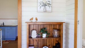 A kitchen with wooden cabinets, a sink, and a wooden shelf with decorative items.