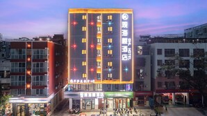 A hotel with multiple floors, illuminated windows, and a sign indicating it is a hotel. - Sanya Guanhailou Hotel (Sanya)