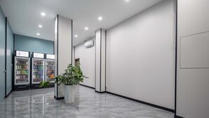 A modern, well-lit hallway with vending machines, a potted plant, and a clean, polished floor. - Sanya Guanhailou Hotel (Sanya)