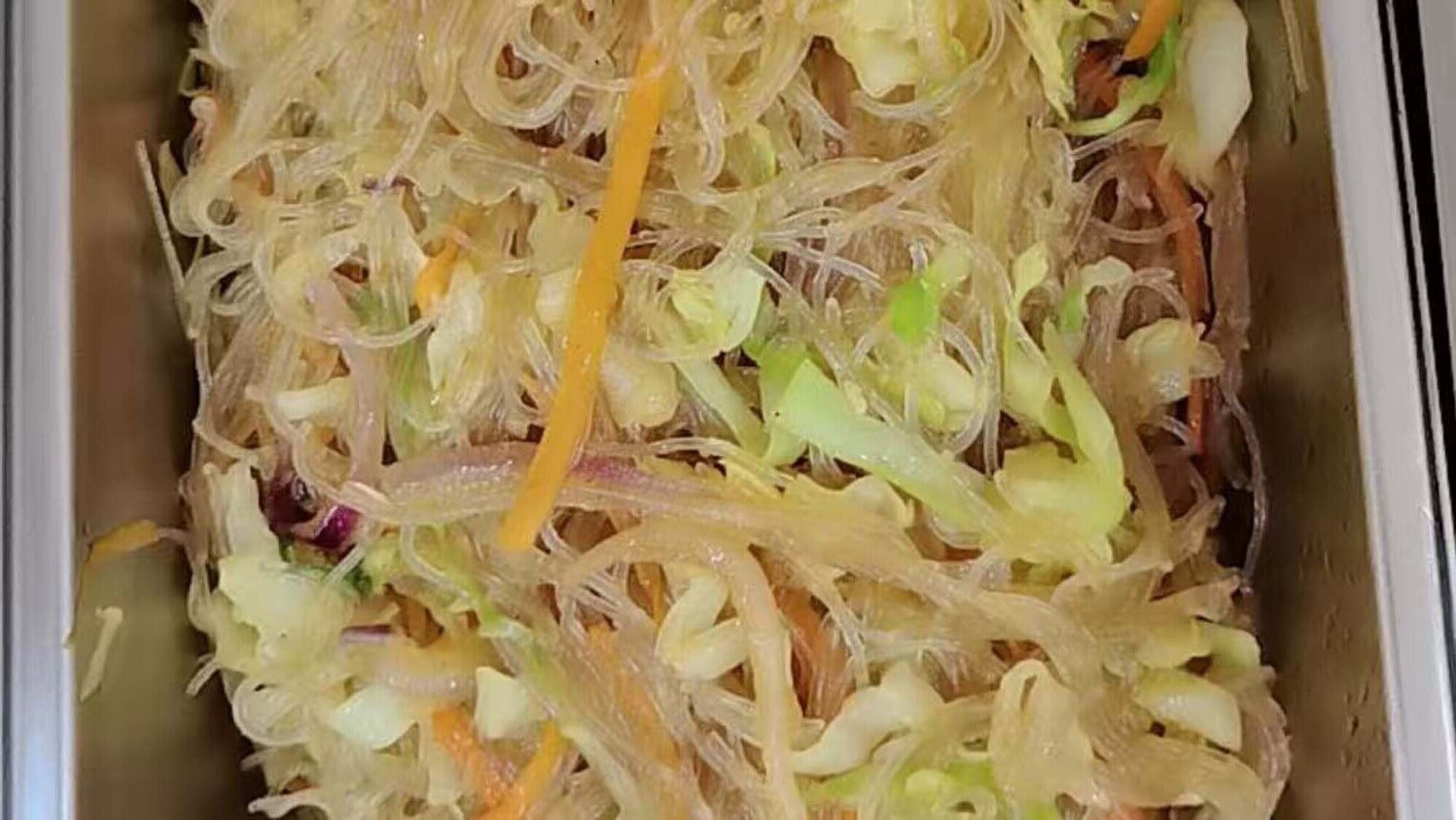 Primer plano de un plato con vegetales desmenuzados y posiblemente algo de carne.