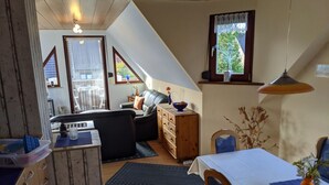 Un espace de vie chaleureux de style loft, comprenant un coin repas, un canapé et un meuble en bois.