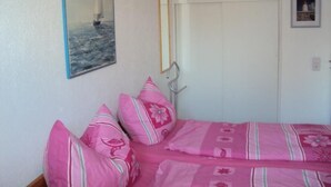 A bedroom with a bed, pillows, a framed picture, and a wardrobe. - Pratzat by Interhome (Büsum)