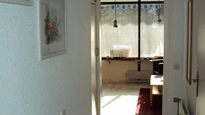 A hallway leading to a room with a radiator, a door, and a window with blinds. - Pratzat by Interhome (Büsum)