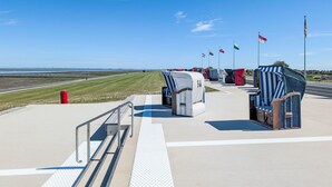 Eine Flugsicherungsbrücke am Flughafen, mit blauem Himmel, Rasenstartbahn und Flaggen.