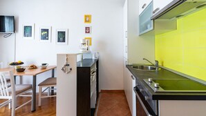 Eine moderne Küche mit Essbereich, ausgestattet mit einem Holztisch, Stühlen und einer Kaffeemaschine.