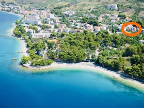 An aerial view of a coastal town with a beach, buildings, and greenery. - Wohnung "Slaven" mit Blick auf das Wasser by Interhome (Podgora)