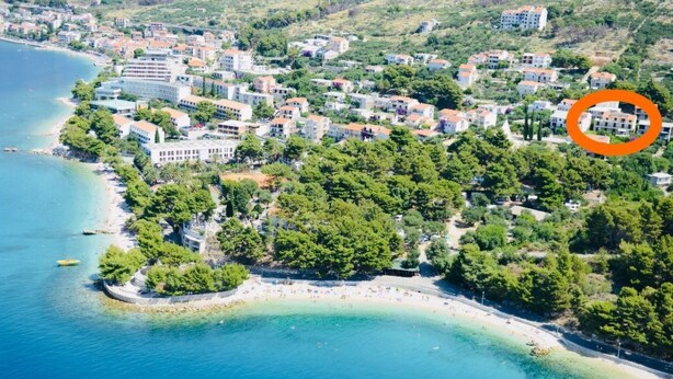 An aerial view of a coastal town with a beach, buildings, and greenery. - "Slaven" mit Blick auf das Wasser by Interhome (Podgora)
