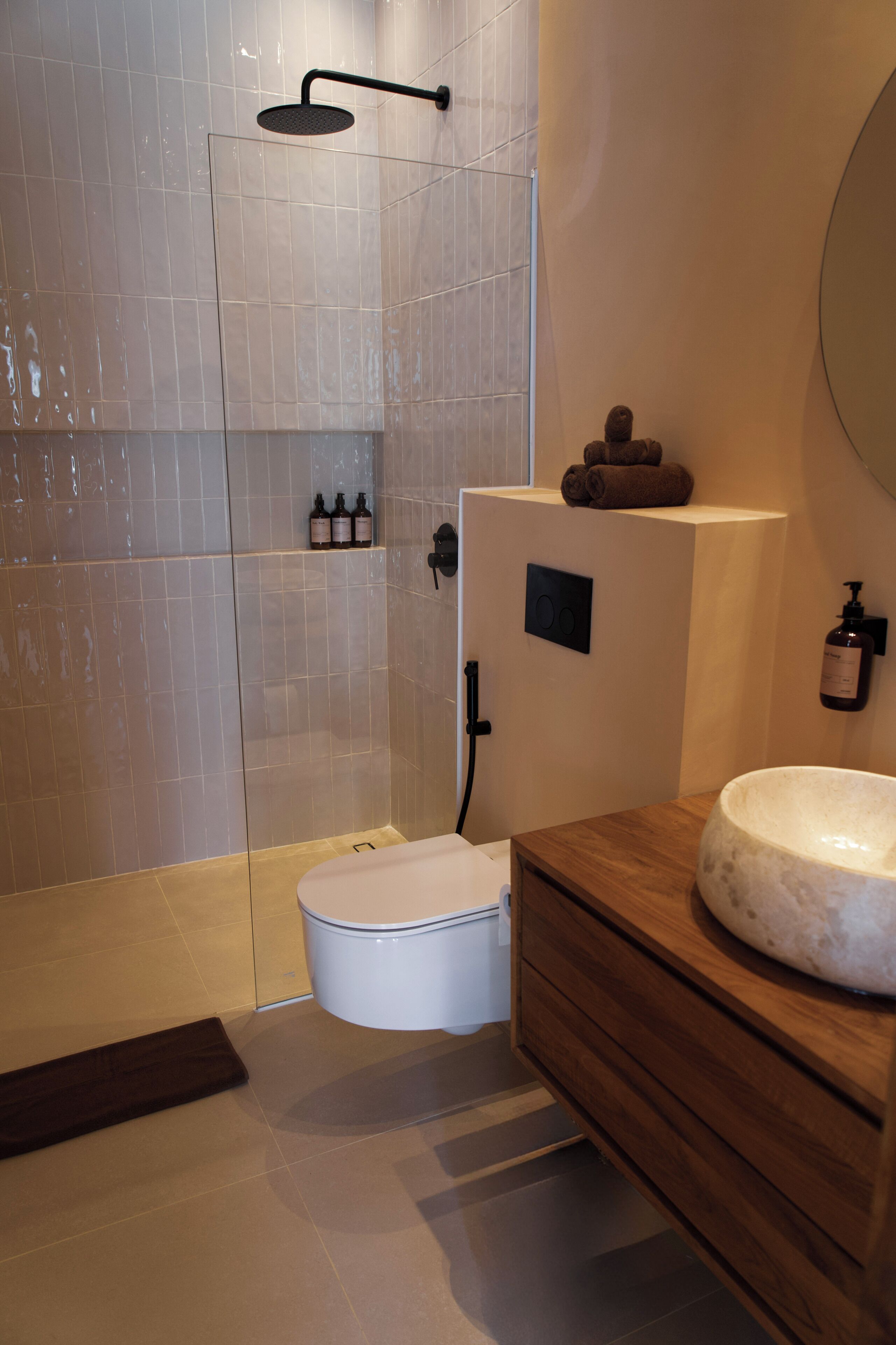 Et moderne badeværelse med brusebad, toilet og vaskemøbel.