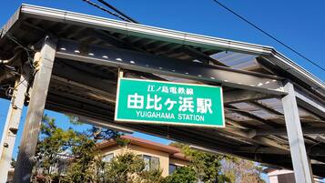 Señal de estación para Yuighama Station con un cielo despejado al fondo.