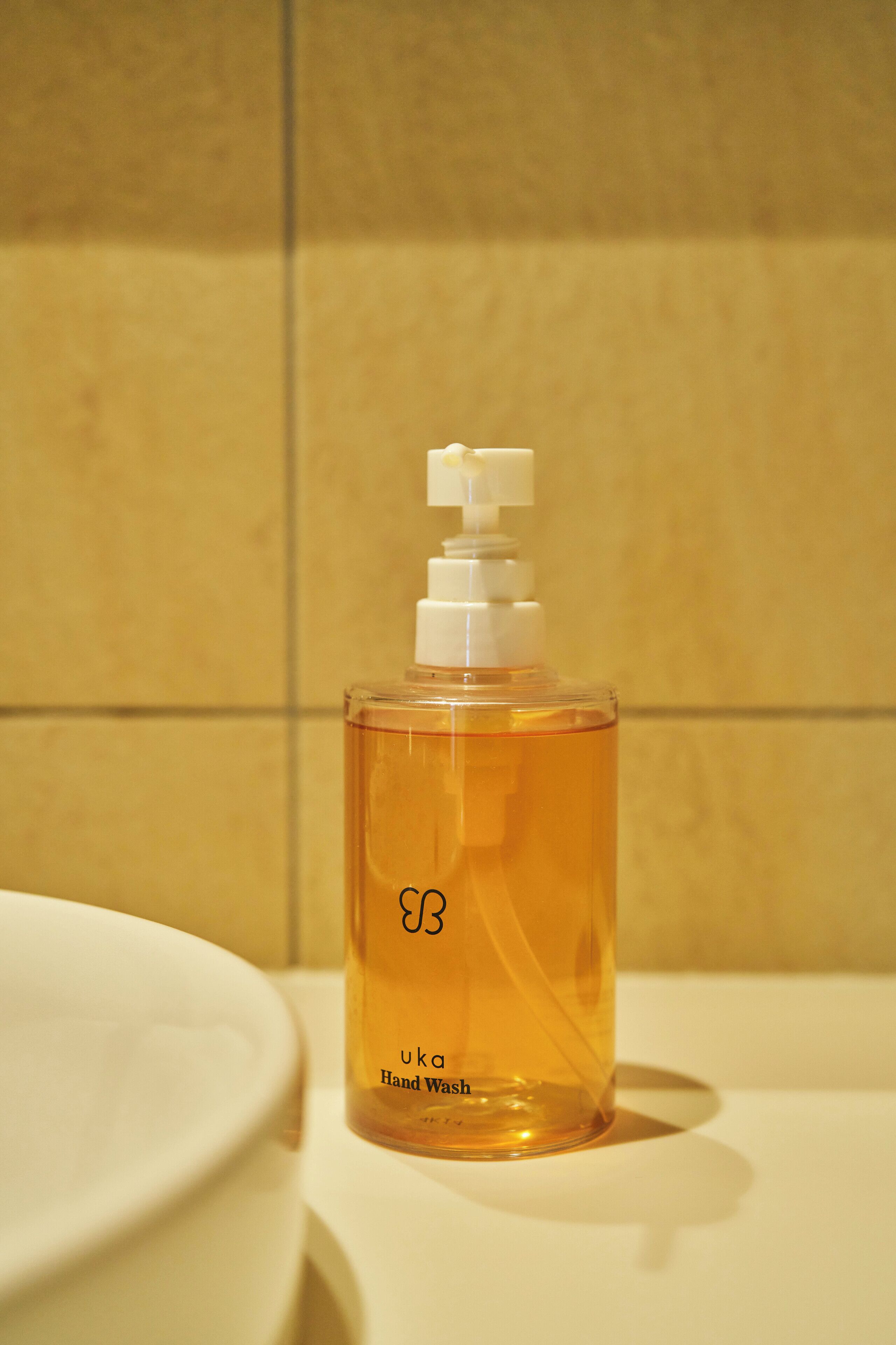 A hand wash bottle with a pump dispenser on a bathroom counter.