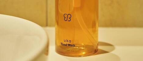 A hand wash bottle with a pump dispenser on a bathroom counter.