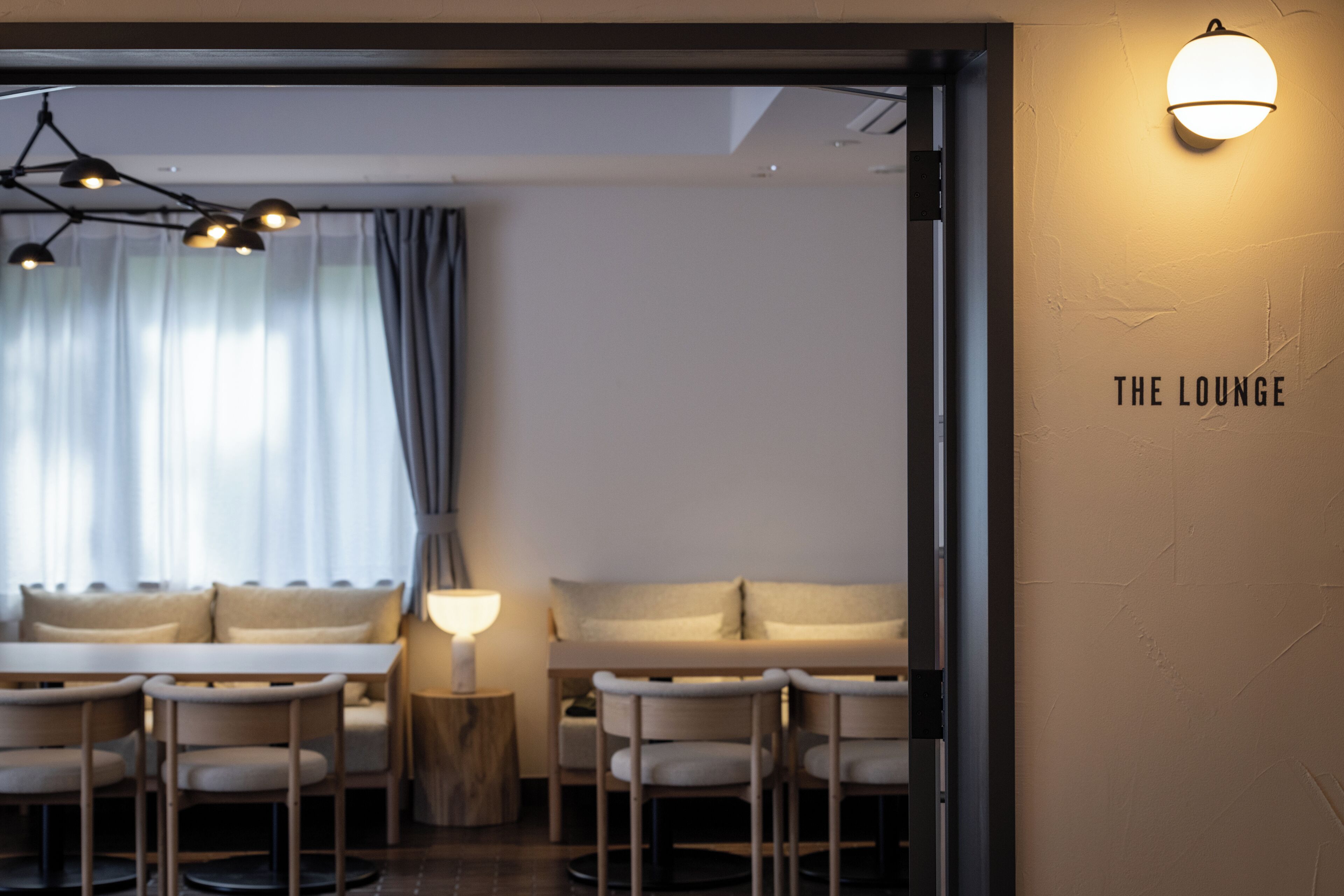 Un salon moderne avec un canapé, des fauteuils, une table et une lampe.