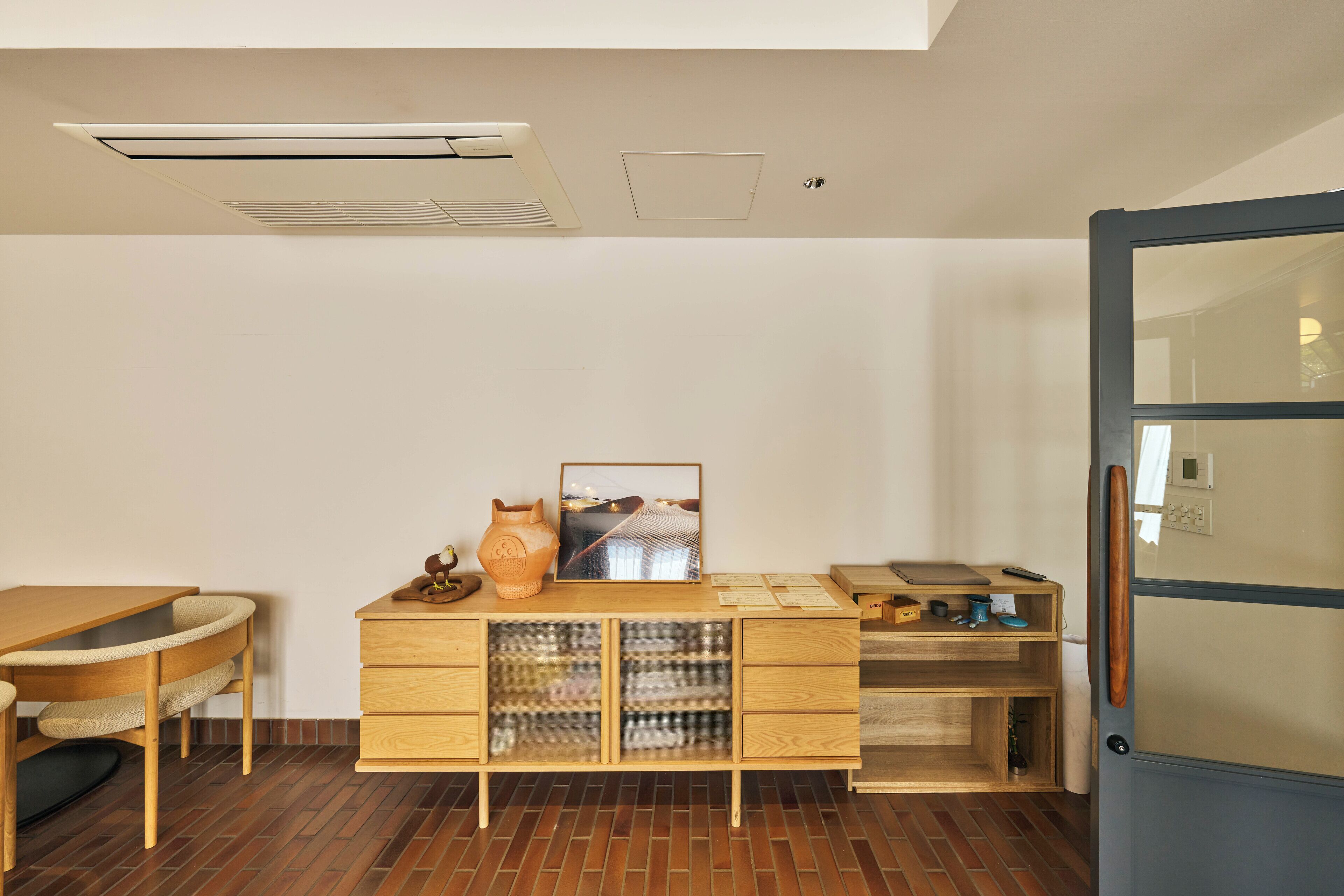 A modern kitchen with a wooden countertop, a built-in oven, and a refrigerator.
