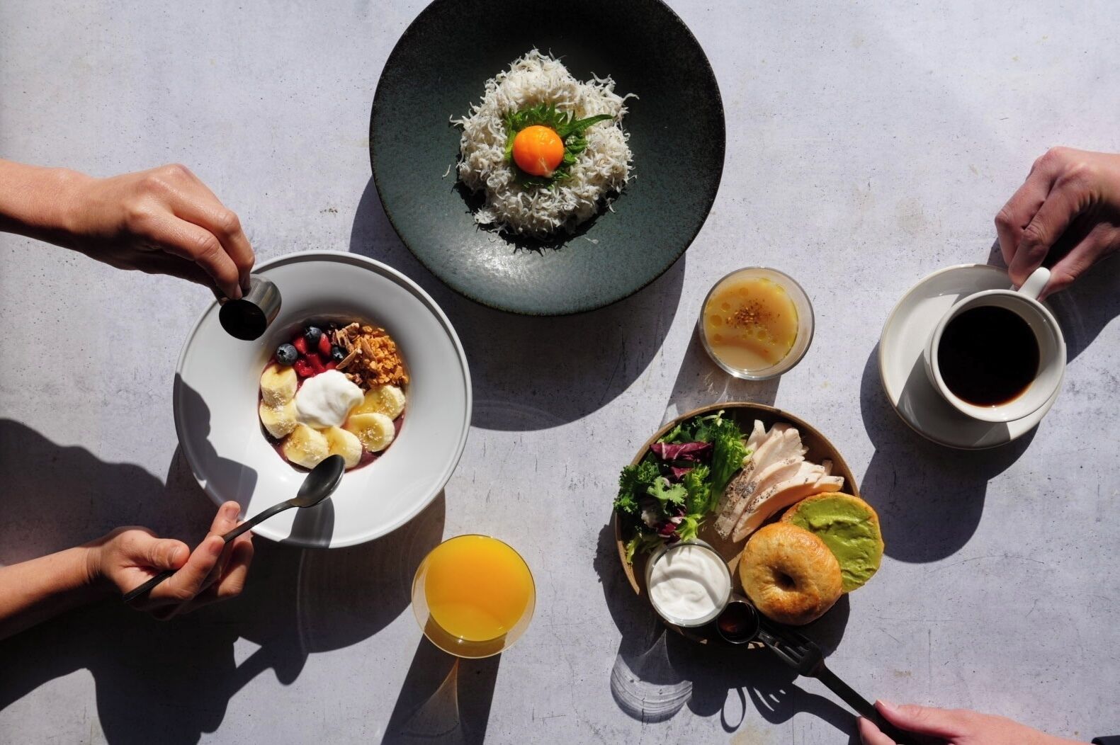 A breakfast setting with various dishes including cereal, fruit, and eggs on a table.