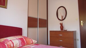 A bedroom with a bed, a dresser, a mirror, and a sliding closet door. - mit Balkon by Interhome (Trogir/Slatine)