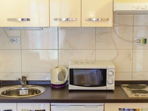 Réfrigérateur, micro-ondes, batterie de cuisine, vaisselle et ustensiles