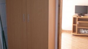 A room with a large wooden wardrobe, a television on a wooden stand, and a tiled floor. - in Poljica-Marina by Interhome (Trogir)