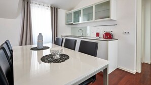 Eine moderne Küche mit weißen Schränken, einer eingebauten Mikrowelle und einem roten Toaster.