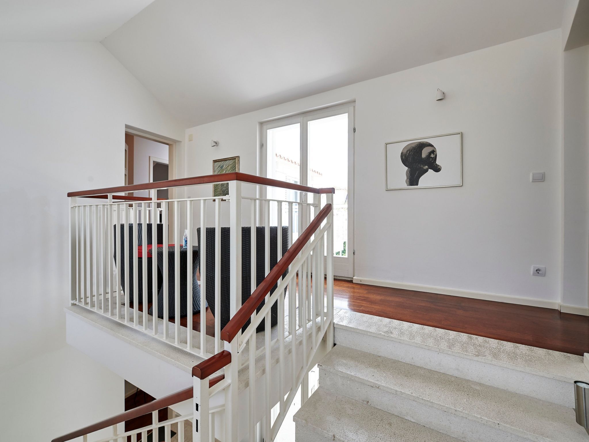 A staircase with white railings and wooden handrails leading to a second floor.