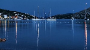 Ein Yachthafen mit mehreren Segelbooten bei Nacht.